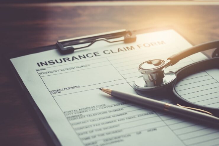 health insurance claim form with stethoscope on wood table selective focus